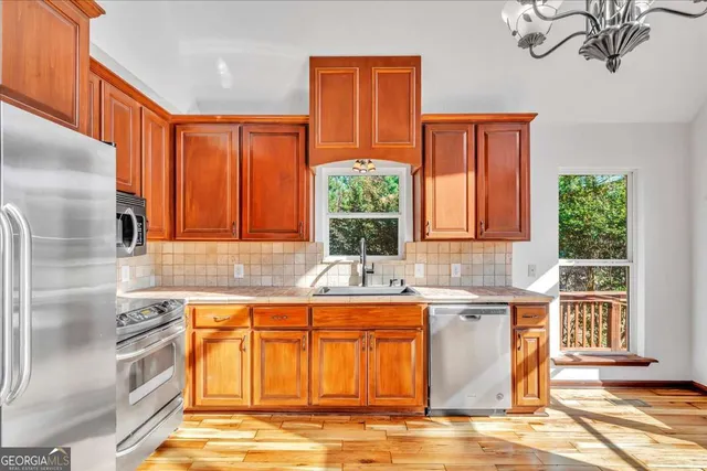a kitchen with stainless steel appliances granite countertop a stove a sink and a microwave