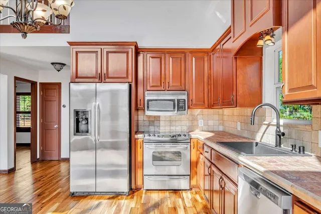 a kitchen with granite countertop stainless steel appliances a refrigerator and cabinets