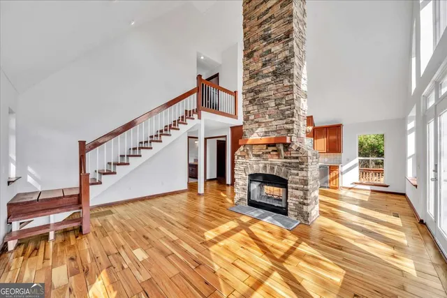 a view of a livingroom with a fireplace wooden floor and staircase