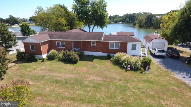 an aerial view of a house with yard and lake view