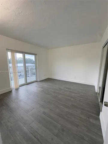 an empty room with wooden floor and sliding door