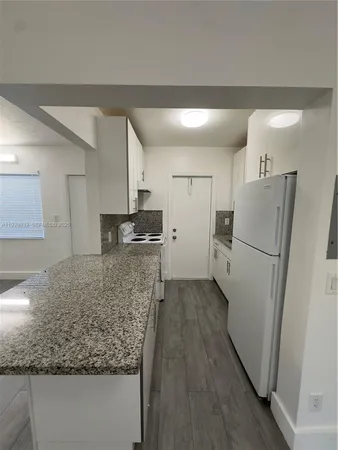 a kitchen with stainless steel appliances granite countertop a refrigerator and a sink