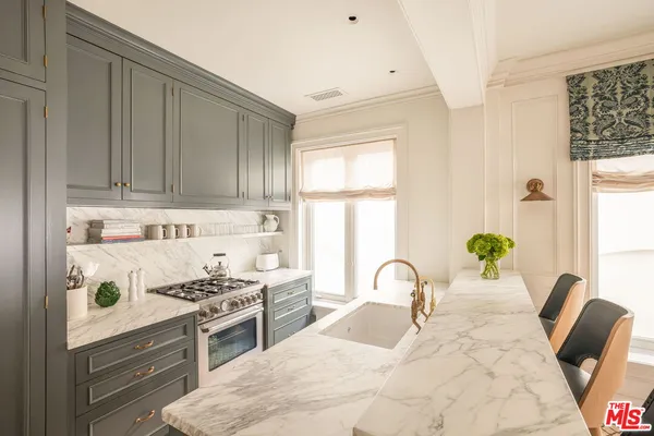 a kitchen with a stove a sink and wooden cabinets