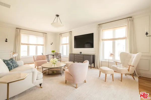 a living room with furniture a flat screen tv and a large window