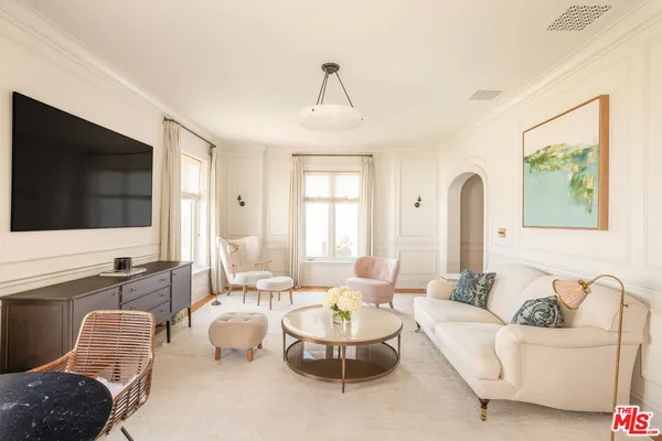 a living room with furniture a flat screen tv and a large window