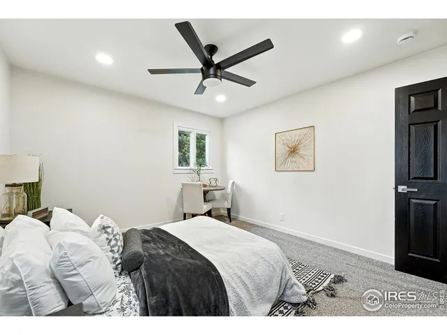a bedroom with a large bed and a ceiling fan