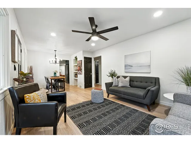 a living room with furniture and a view of kitchen