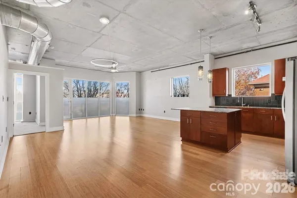 a large room with wooden floors and large windows