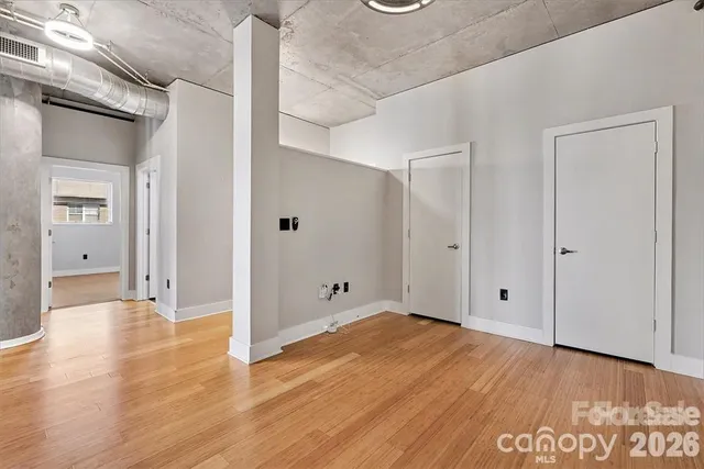 a view of an empty room with wooden floor