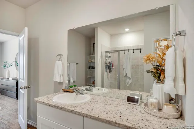 a bathroom with a granite countertop sink and a mirror