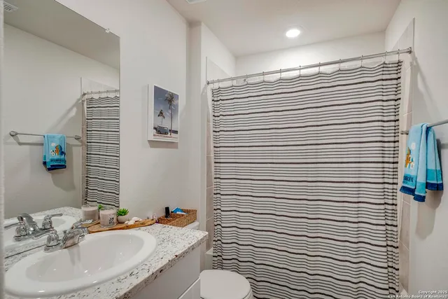 a bathroom with a sink toilet and shower