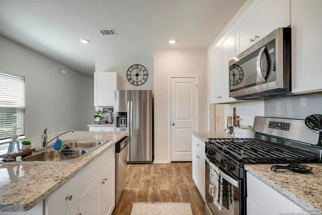 a kitchen with granite countertop stainless steel appliances window a sink and cabinets