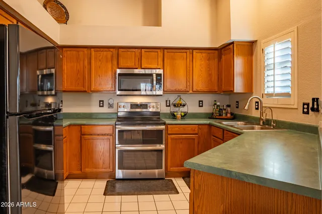 a kitchen with a sink a counter top space appliances and cabinets