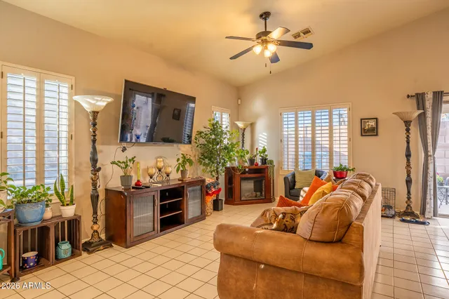 a living room with furniture ceiling fan and a window
