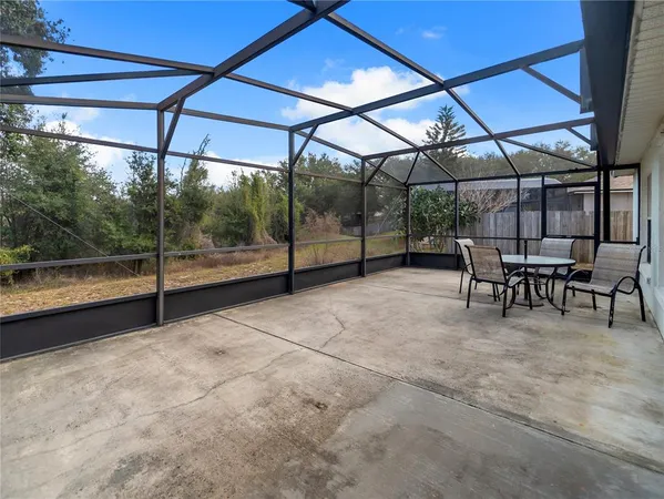 a view of a patio with table and chairs and a barbeque