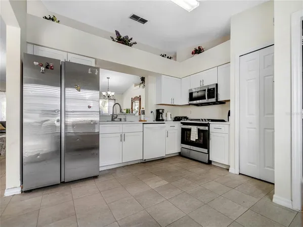 a kitchen with stainless steel appliances a refrigerator sink and microwave