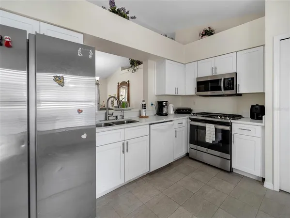 a kitchen with a refrigerator and a stove top oven