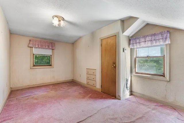 an empty room with windows and closet