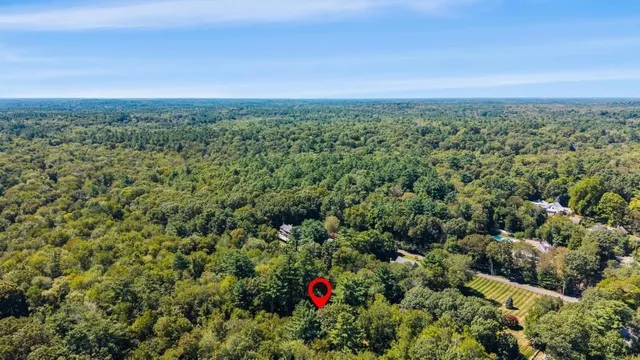 an aerial view of residential building with green space and fog