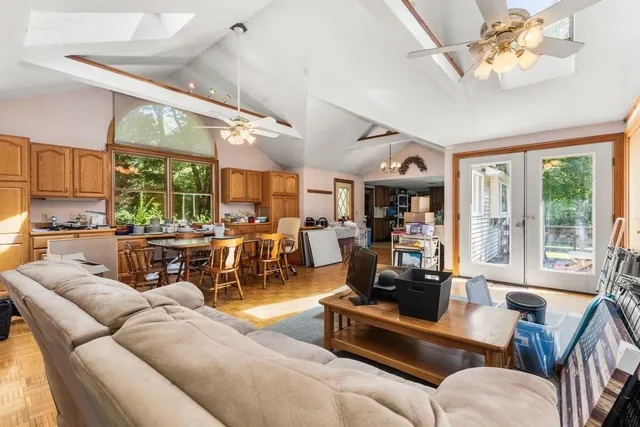 a living room with furniture kitchen view and a large window