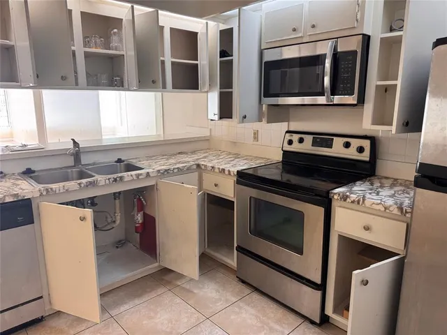a kitchen with stainless steel appliances granite countertop a stove microwave and cabinets