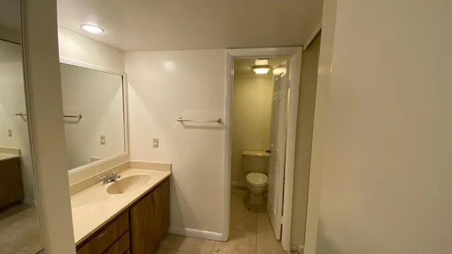 a bathroom with a granite countertop sink mirror and a bathtub