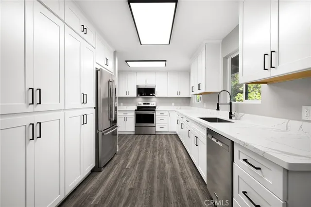 a kitchen with white cabinets and stainless steel appliances