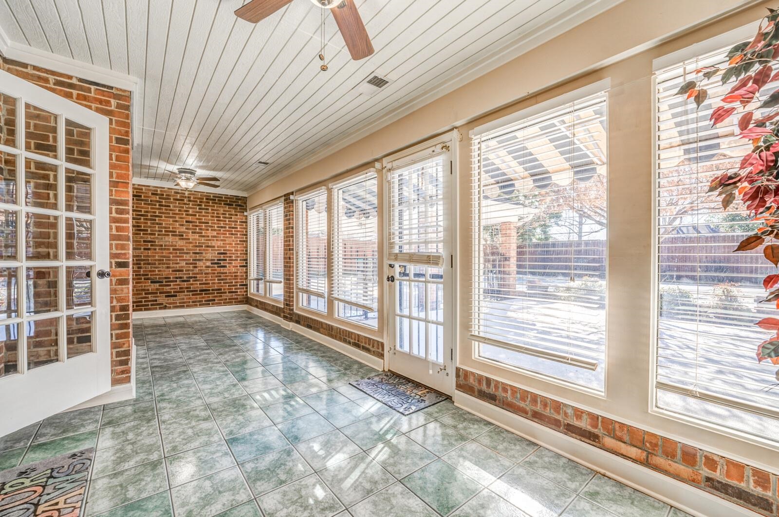 2997 Riverdale Road Memphis, TN 38119 - Photo 13 of 35 Unfurnished sunroom featuring tile patterned floors, wooden ceiling, and brick wall
