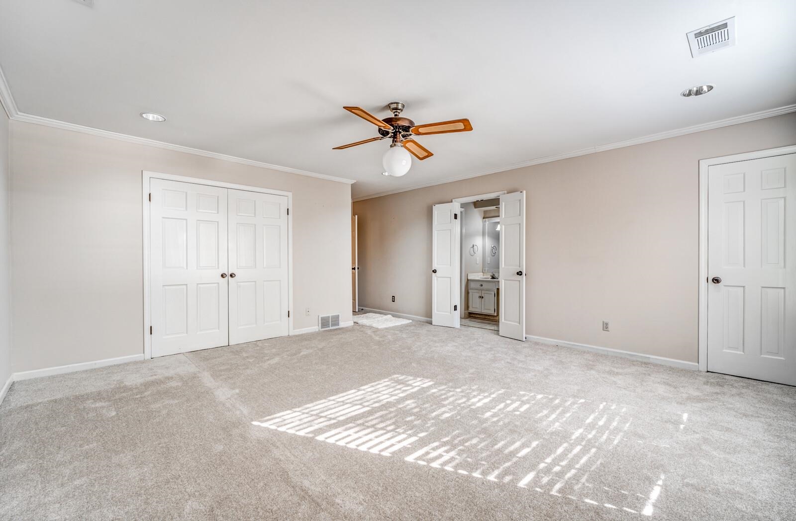 2997 Riverdale Road Memphis, TN 38119 - Photo 16 of 35 Unfurnished bedroom with ornamental molding, carpet, ceiling fan, connected bathroom, and a closet