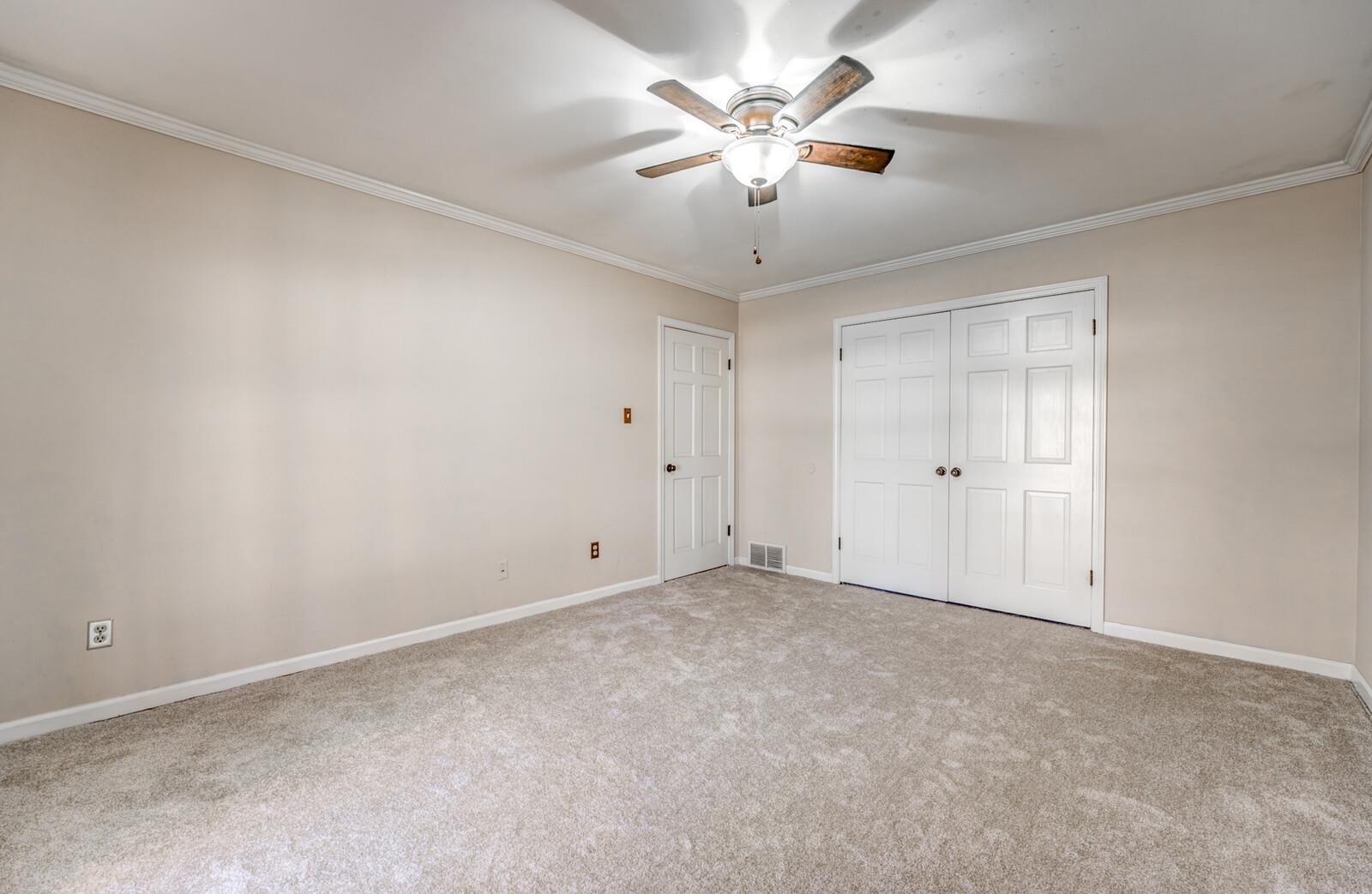 2997 Riverdale Road Memphis, TN 38119 - Photo 23 of 35 Unfurnished bedroom with ornamental molding, light colored carpet, a closet, and a ceiling fan