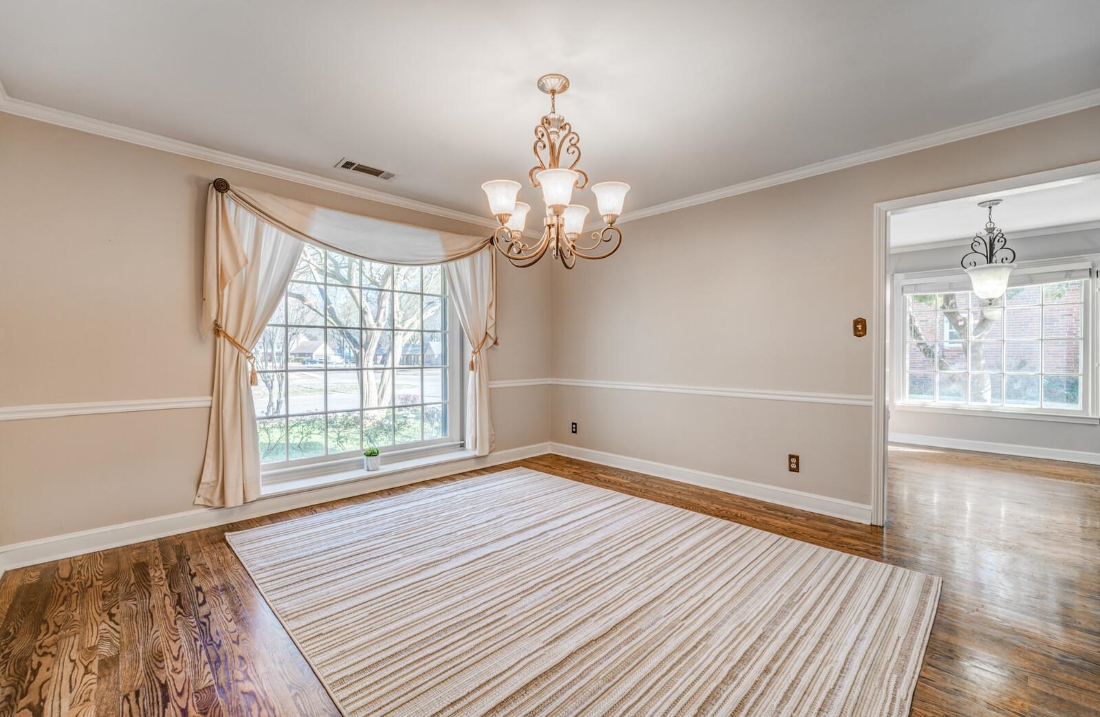2997 Riverdale Road Memphis, TN 38119 - Photo 7 of 35 Unfurnished room with hanging lights, wood finished floors, and ornamental molding