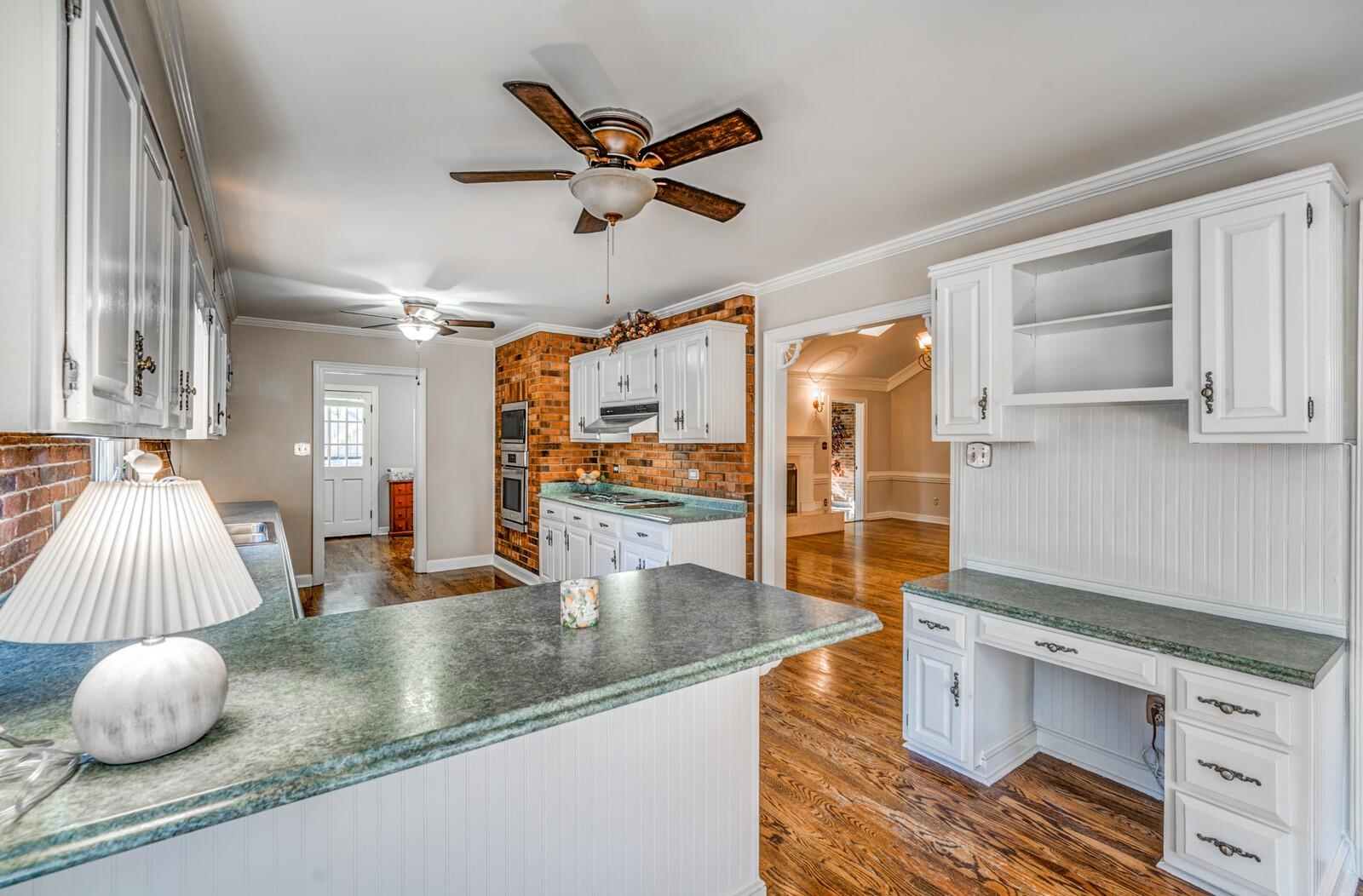2997 Riverdale Road Memphis, TN 38119 - Photo 10 of 35 Kitchen featuring white cabinetry, ornamental molding, dark wood-style flooring, open shelves, and dark countertops