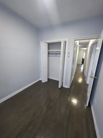 an empty room with wooden floor and mirror