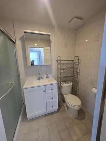 a bathroom with a granite countertop sink toilet and mirror