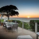 a view of a roof deck with table and chairs a barbeque with wooden floor and fence