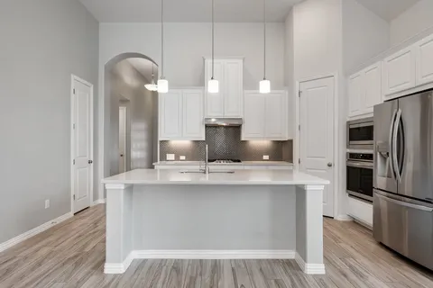 a kitchen with kitchen island a sink appliances and cabinets