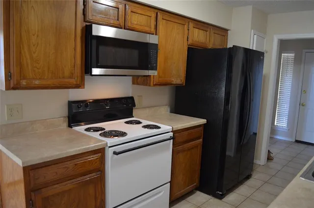 a kitchen with a refrigerator and a stove top oven