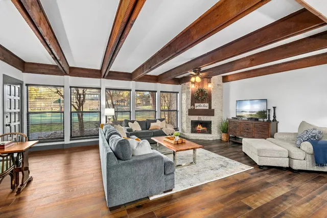 a living room with furniture floor to ceiling window and wooden floor