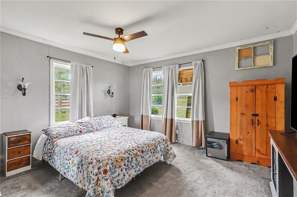 381 River Bend Road Southwest Plainville, GA 30733 - Photo 12 of 28 a bedroom with a bed and a chandelier