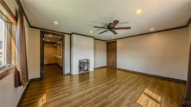 a view of a hallway with wooden floor and a ceiling fan