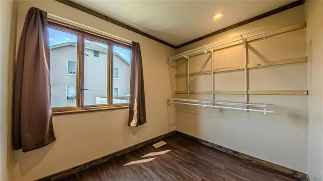 a view of a room with wooden floor and windows