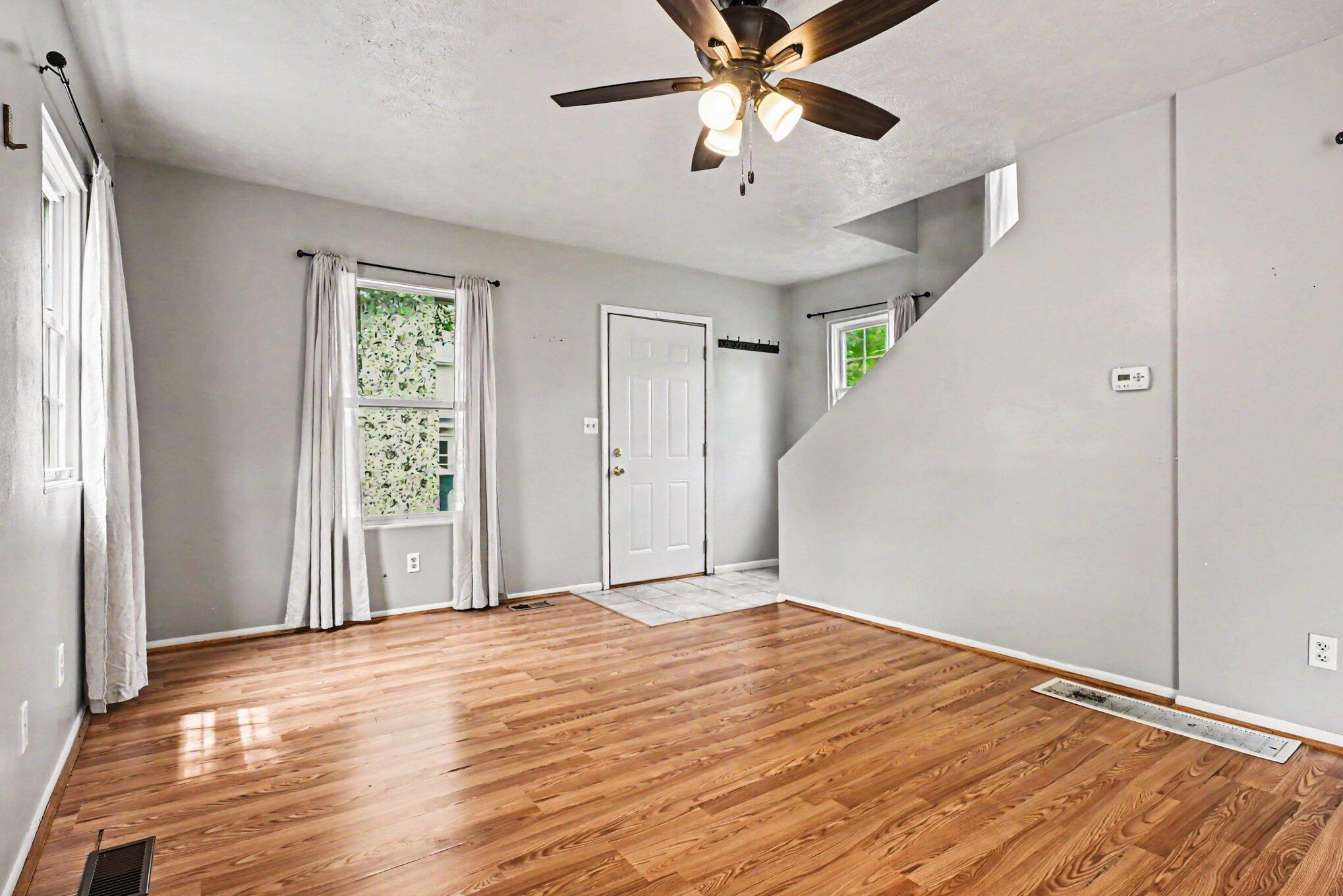 115 McClung Road La Porte, IN 46350 - Photo 4 of 31 an empty room with wooden floor fan and windows
