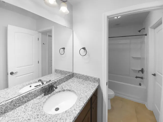 a bathroom with a granite countertop bathtub shower sink and mirror