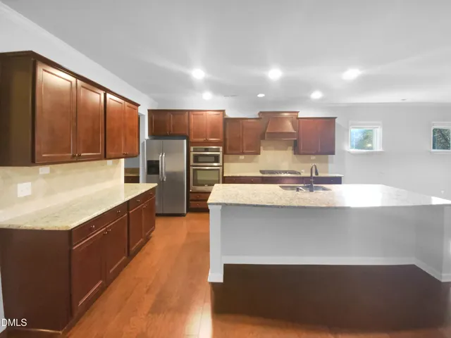 a large kitchen with kitchen island granite countertop a large counter top stainless steel appliances and cabinets