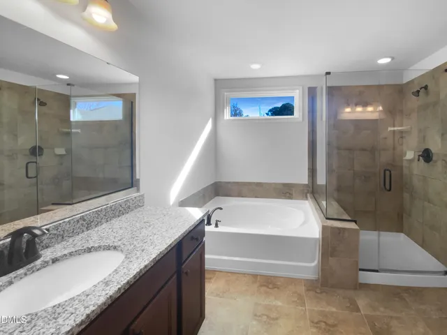 a bathroom with a granite countertop sink a bathtub and shower