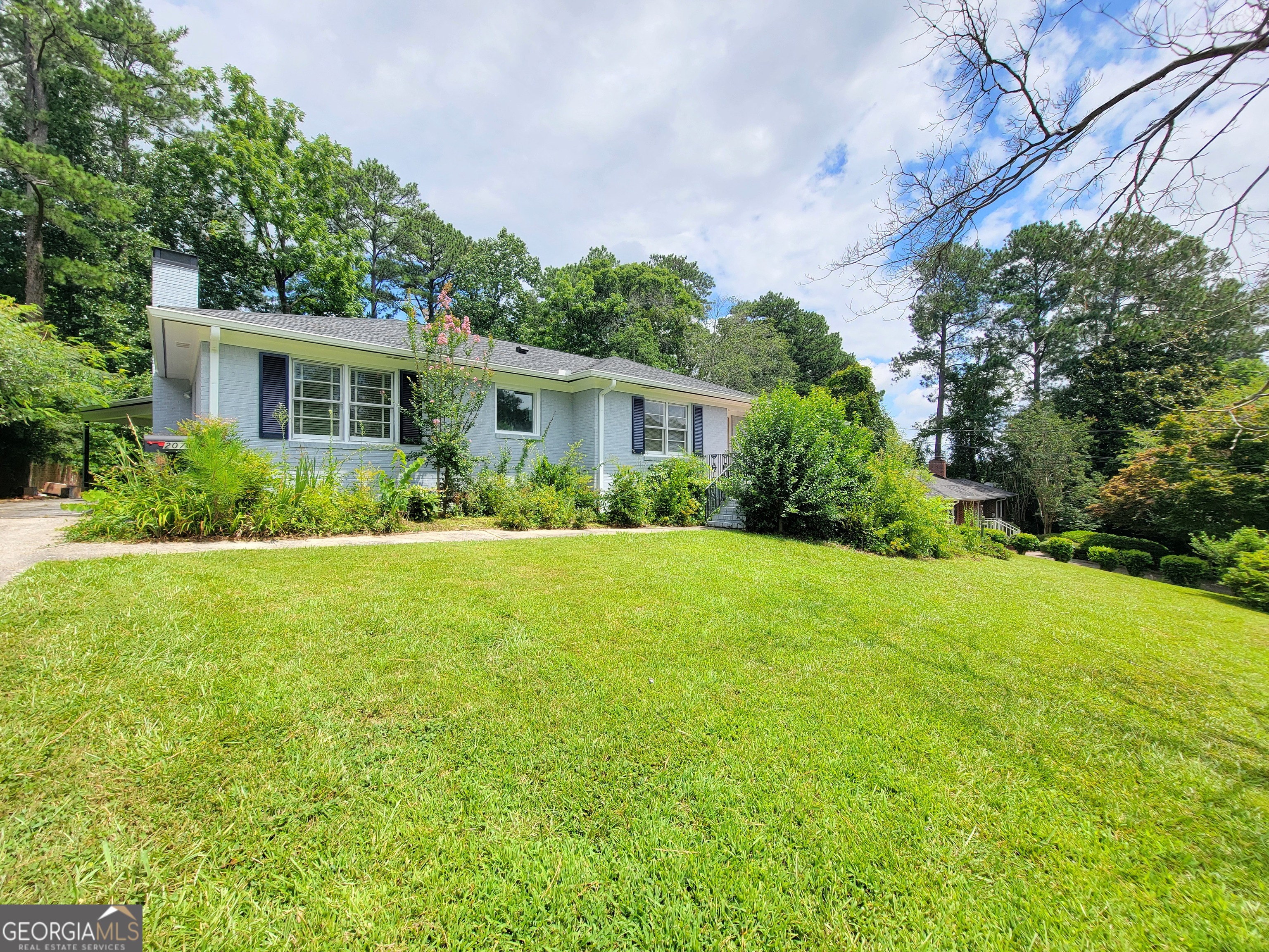 a view of backyard of house with green space