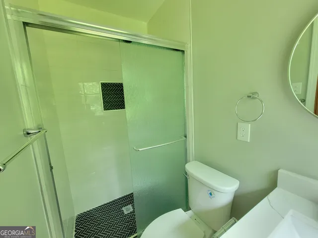 a bathroom with a toilet and a shower