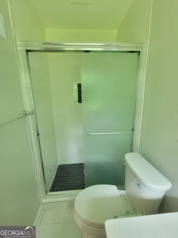 a white toilet sitting next to a shower