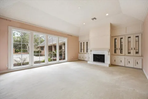 a view of an empty room with a fireplace and a large window