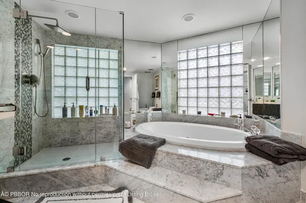 a bathroom with a large tub shower and checkered floor